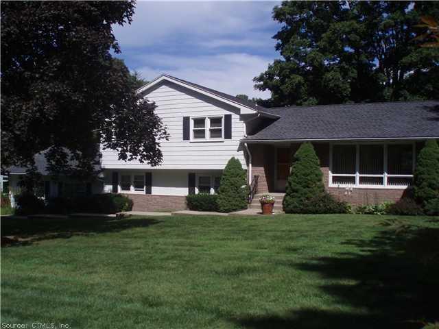 a front view of a house with a garden and trees