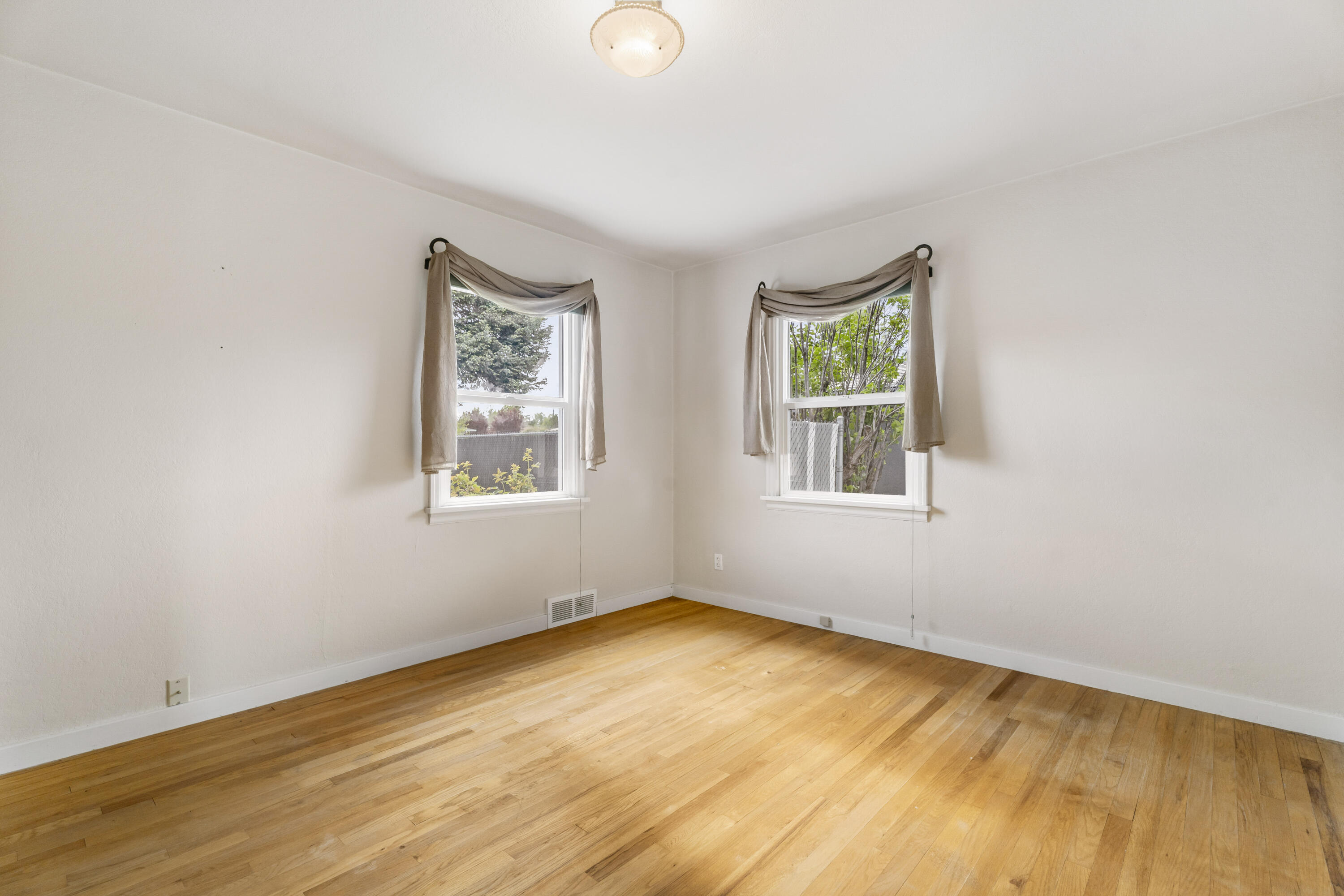 946 Southwest 13th Street Redmond, OR 97756 - Photo 28 of 49 a view of an empty room with wooden floor and a window