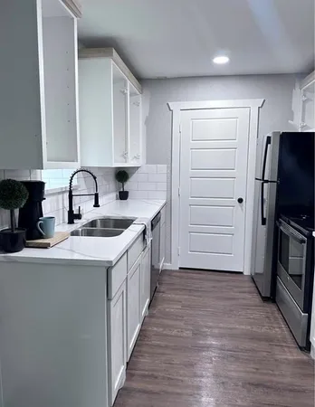 a kitchen with a sink refrigerator and cabinets