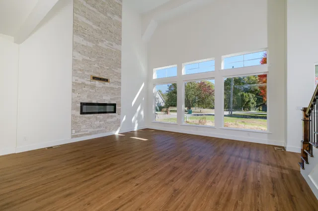 a view of empty room with wooden floor and window