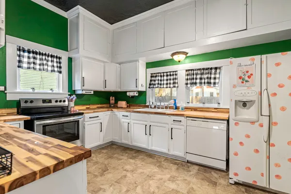 a kitchen with stainless steel appliances granite countertop a stove a sink and a refrigerator