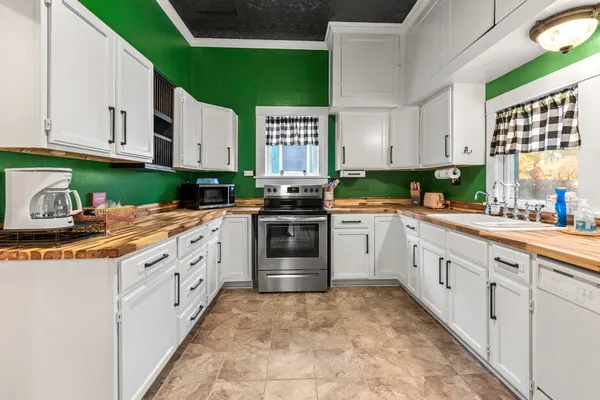 a kitchen with granite countertop a stove sink and cabinets