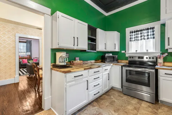 a kitchen with granite countertop a stove top oven cabinetry a sink and a refrigerator