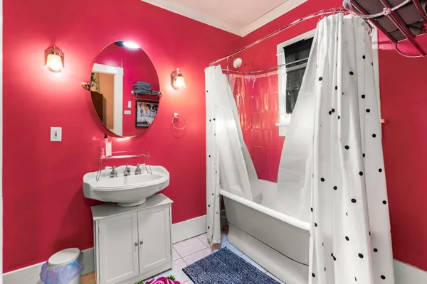 a bathroom with a sink mirror and tub