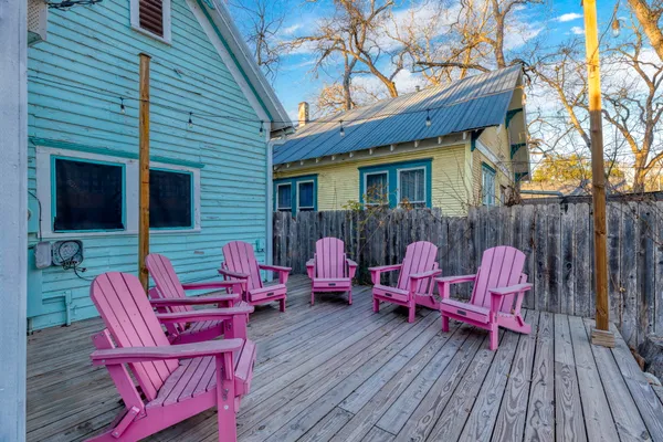 a backyard of a house with wooden floor chairs sofa and barbecue oven