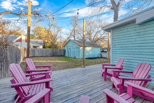 a view of a deck with table and chairs with wooden floor and fence