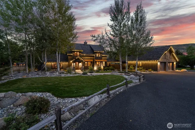 a view of a house with a big yard and a large trees