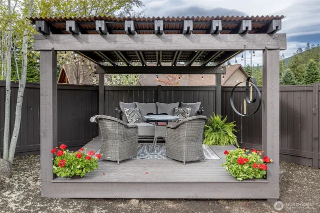 a patio with table and chairs potted plants