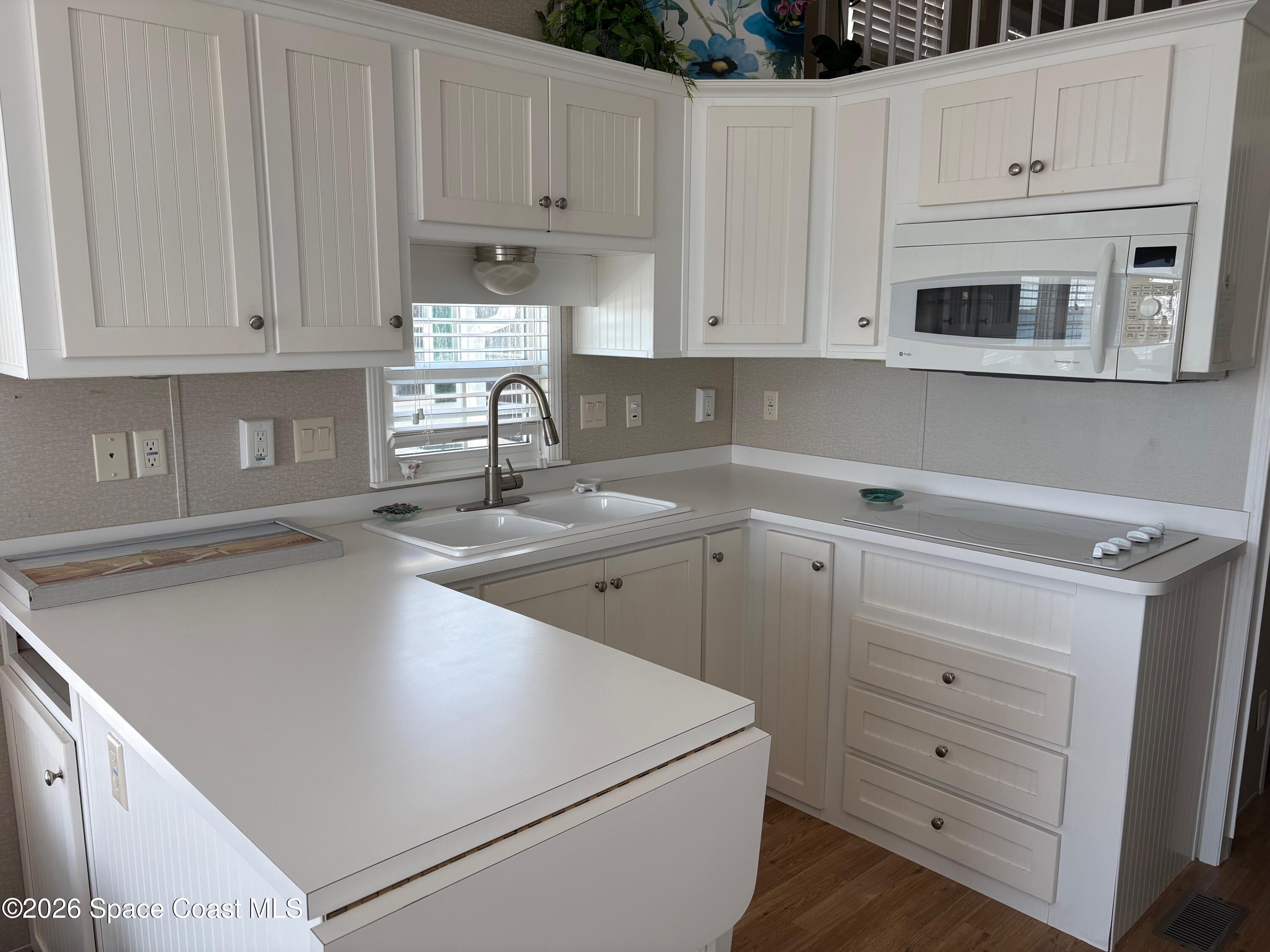 2912 Dockside Lane, Unit 2 Melbourne Beach, FL 32951 - Photo 22 of 66 a kitchen with white cabinets and white appliances