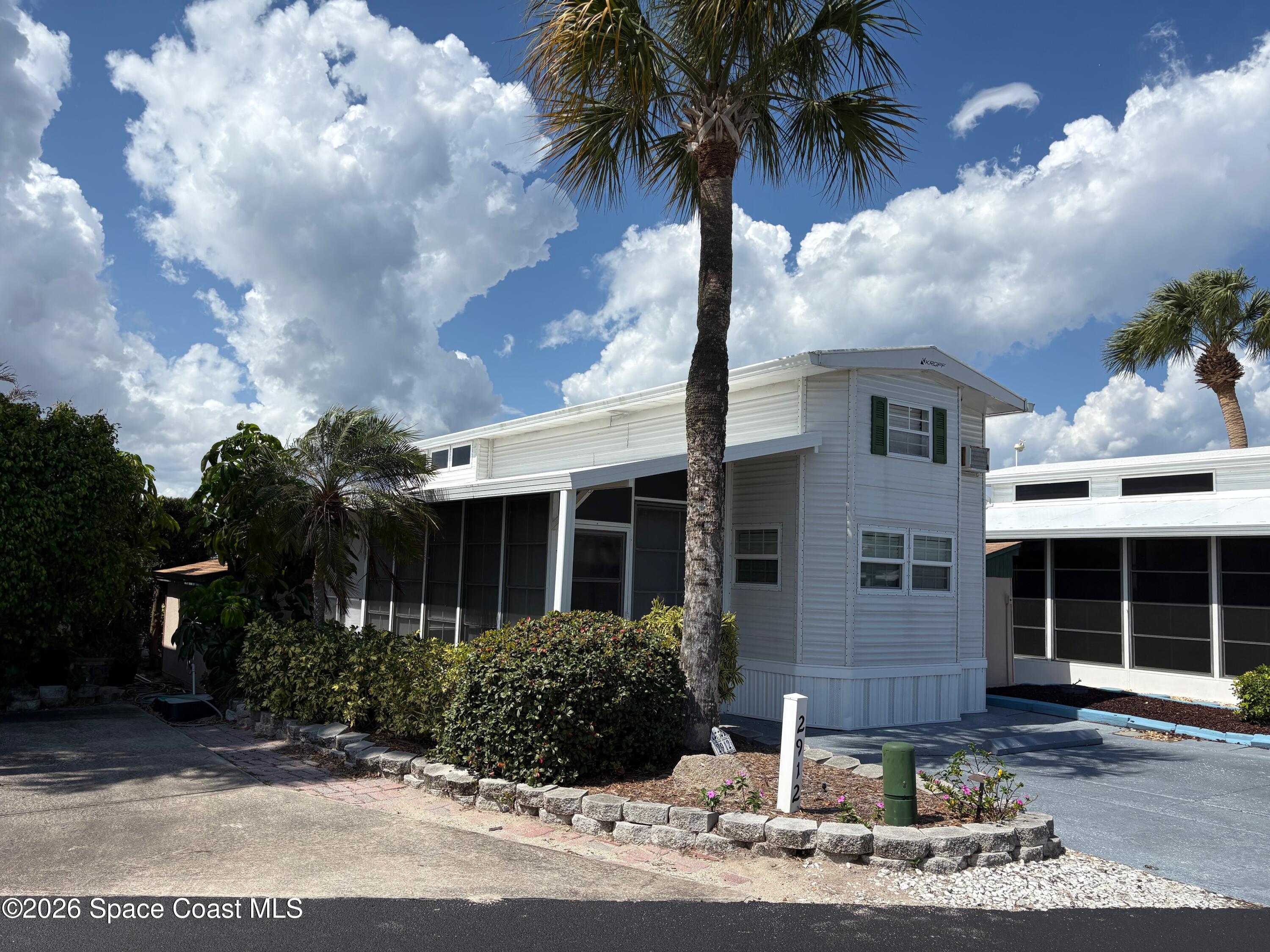 2912 Dockside Lane, Unit 2 Melbourne Beach, FL 32951 - Photo 6 of 66 a front view of a house with garden and yard