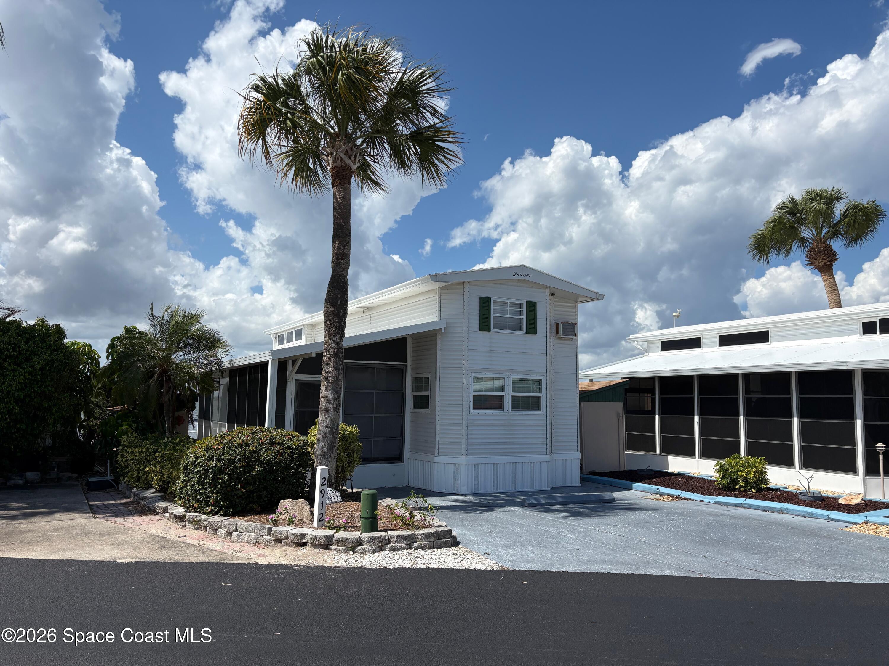 2912 Dockside Lane, Unit 2 Melbourne Beach, FL 32951 - Photo 7 of 66 a front view of a house with yard and parking