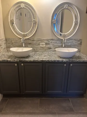 a bathroom with a granite countertop toilet a sink and a mirror