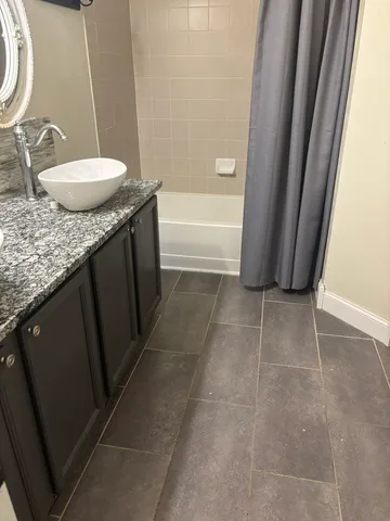 a bathroom with a granite countertop sink and a mirror