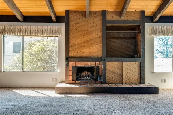 a living room with a fireplace and windows