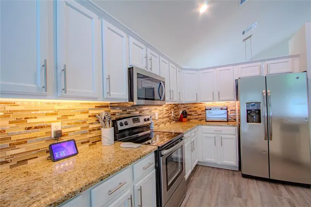 a living room with a table chairs and a wooden floor