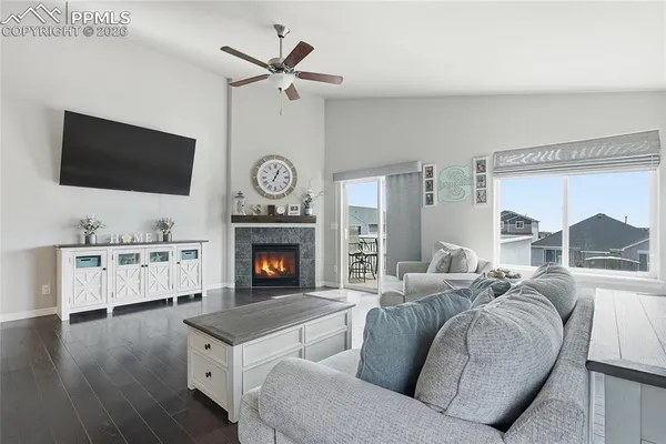 a living room with furniture a flat screen tv and a fireplace