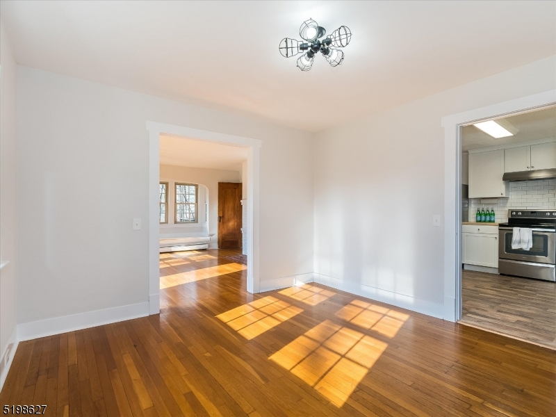 81 Alexander Avenue, Unit 1 Montclair, NJ 07043 - Photo 5 of 15 a view of a room with wooden floor and a kitchen