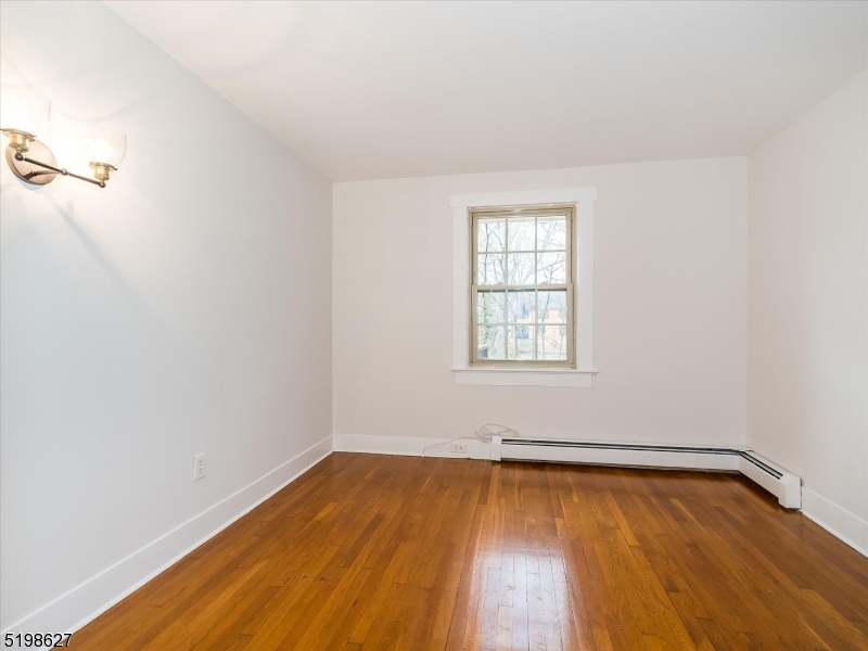 81 Alexander Avenue, Unit 1 Montclair, NJ 07043 - Photo 9 of 15 an empty room with wooden floor and windows