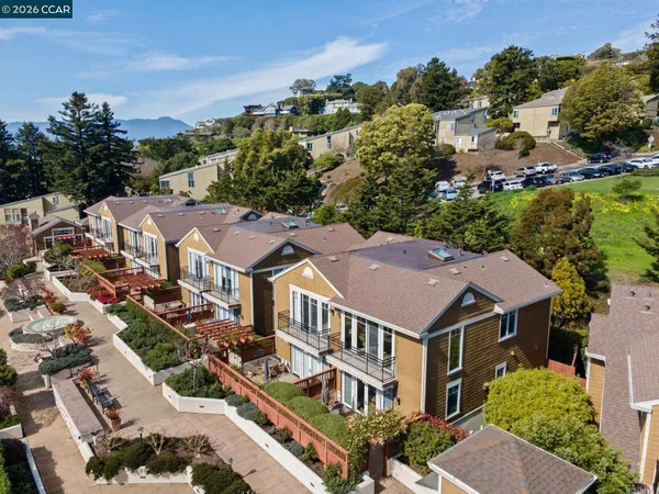 an aerial view of residential houses with a city street