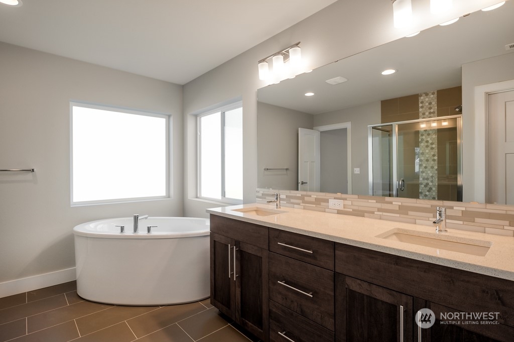 30 177th St S West, Unit IW 81 Bothell, WA 98012 - Photo 31 of 33 a bathroom with a double vanity sink a mirror and a bathtub