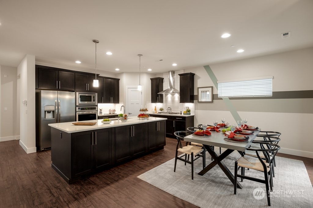 30 177th St S West, Unit IW 81 Bothell, WA 98012 - Photo 10 of 33 a kitchen with stainless steel appliances kitchen island granite countertop a table chairs sink and cabinets