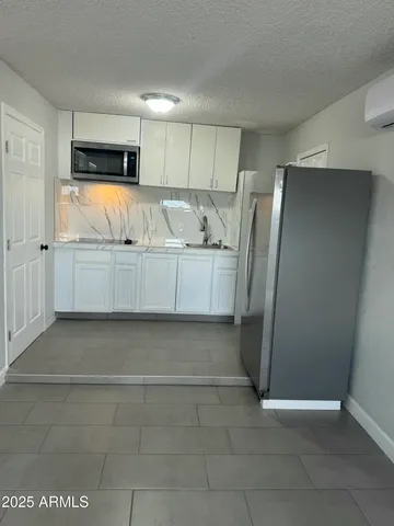 a view of kitchen with refrigerator and window