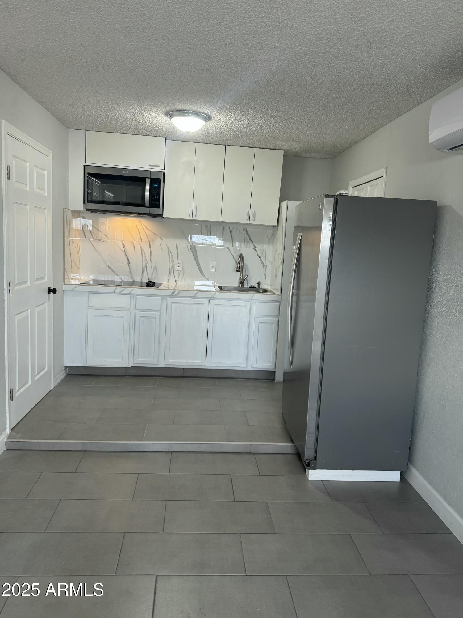 a view of kitchen with refrigerator and window