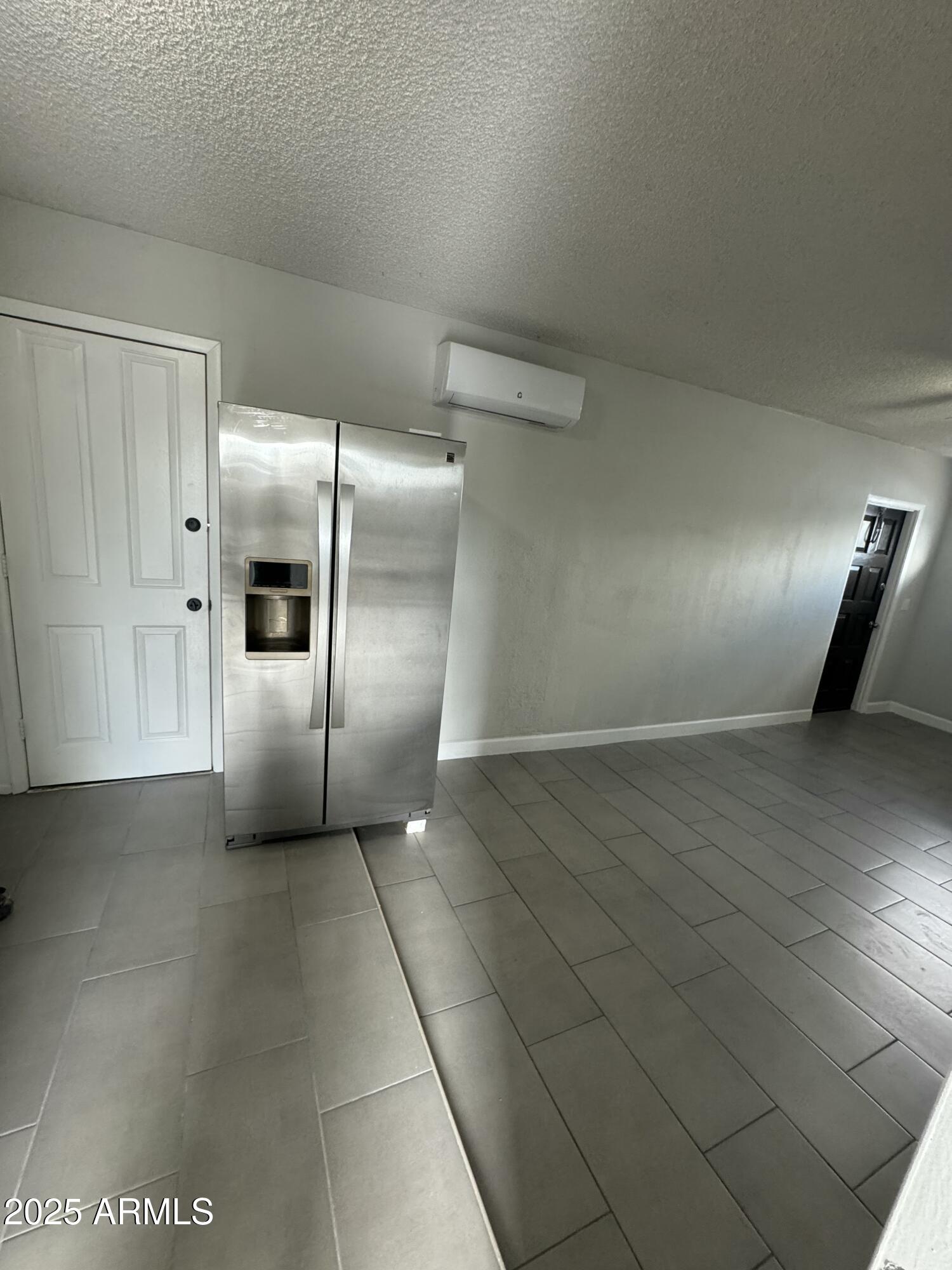 13824 North 33rd Drive, Unit 1 Phoenix, AZ 85053 - Photo 4 of 10 a view of a refrigerator in kitchen and an empty room