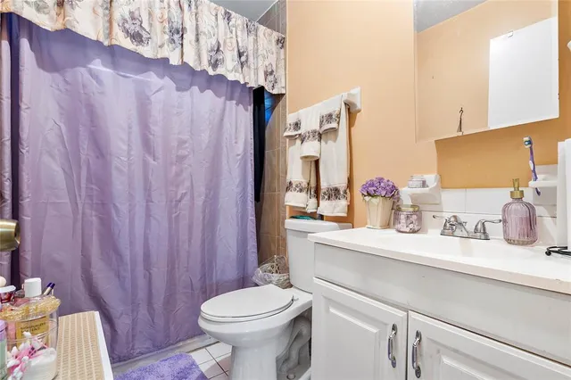 a bathroom with a sink a toilet and shower curtain