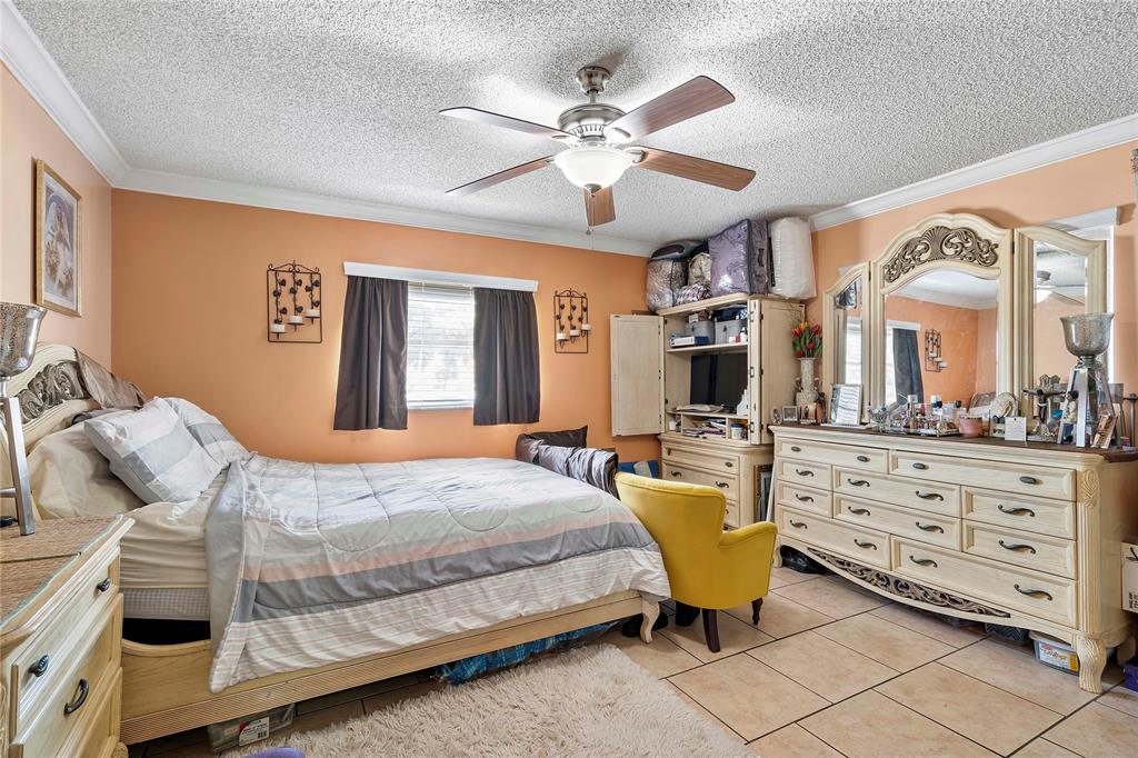 5829 Taylor Street Hollywood, FL 33021 - Photo 29 of 34 a bedroom with a bed a chandelier and a dresser