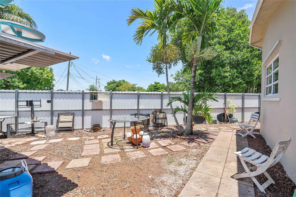 5829 Taylor Street Hollywood, FL 33021 - Photo 32 of 34 a view of a patio with a dining table and chairs with wooden floor