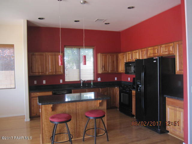 4890 Edgemont Road Prescott Valley, AZ 86314 - Photo 3 of 12 a kitchen with stainless steel appliances kitchen island granite countertop a refrigerator a sink and dishwasher