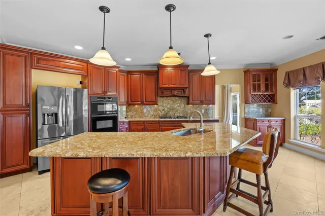 a kitchen with stainless steel appliances granite countertop a stove a refrigerator a oven a sink with a countertop and chairs