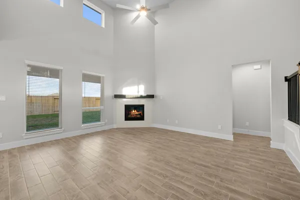 wooden floor fireplace and windows in an empty room