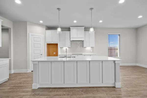 a view of a kitchen with kitchen island a sink stainless steel appliances and cabinets