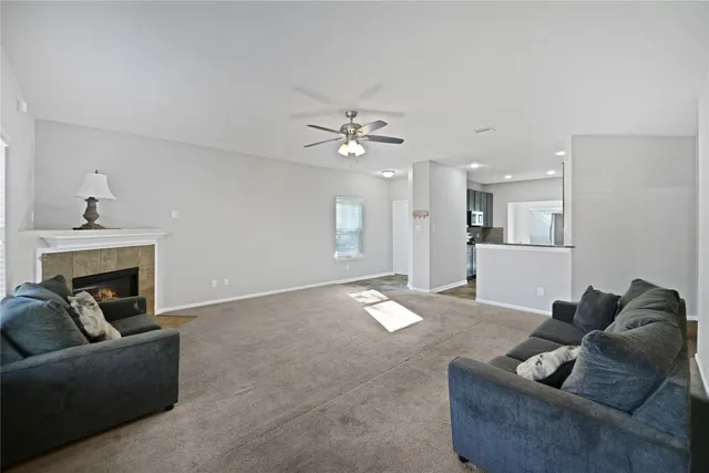 a living room with furniture and a ceiling fan