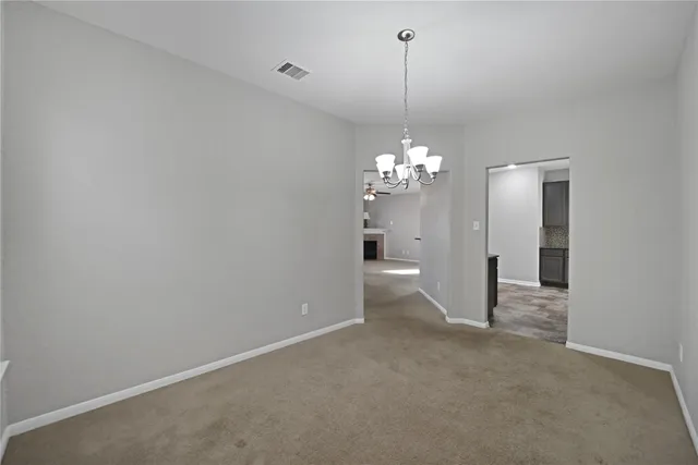 a view of a chandelier in big room and chandelier fan