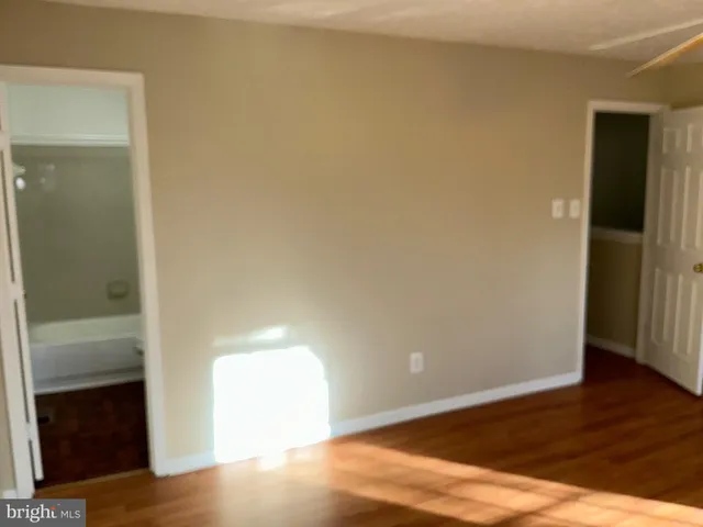 an empty room with wooden floor and closet