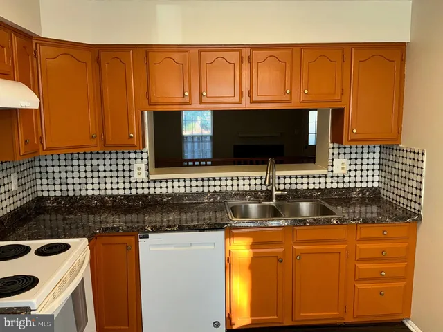 a kitchen with granite countertop a sink and a stove
