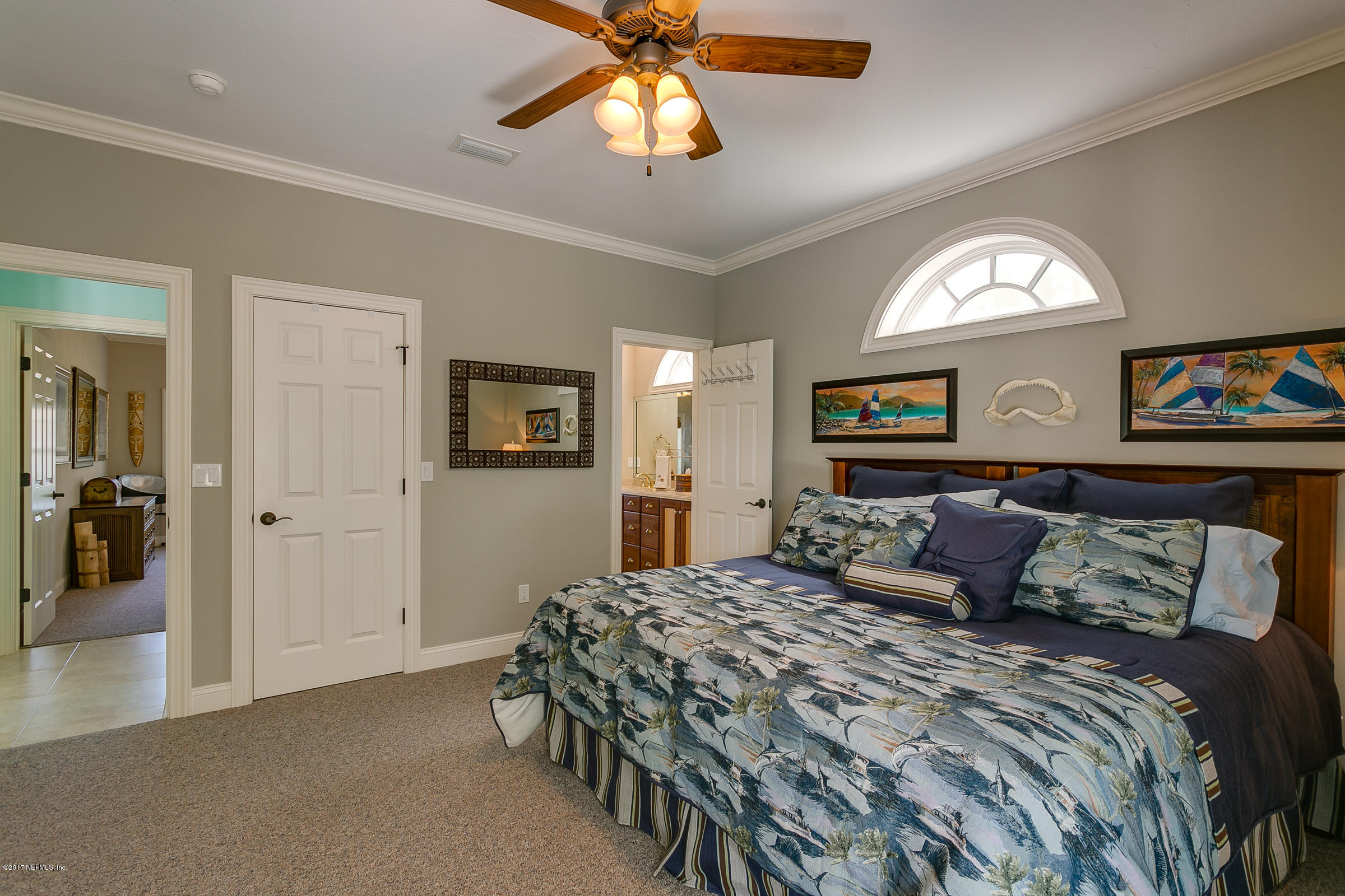 645 Ocean Palm Way St. Augustine, FL 32080 - Photo 12 of 47 a bedroom with a large bed and a chandelier