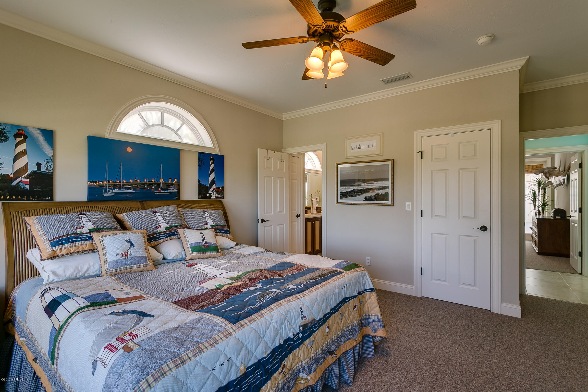 645 Ocean Palm Way St. Augustine, FL 32080 - Photo 14 of 47 a bedroom with a large bed and a chandelier