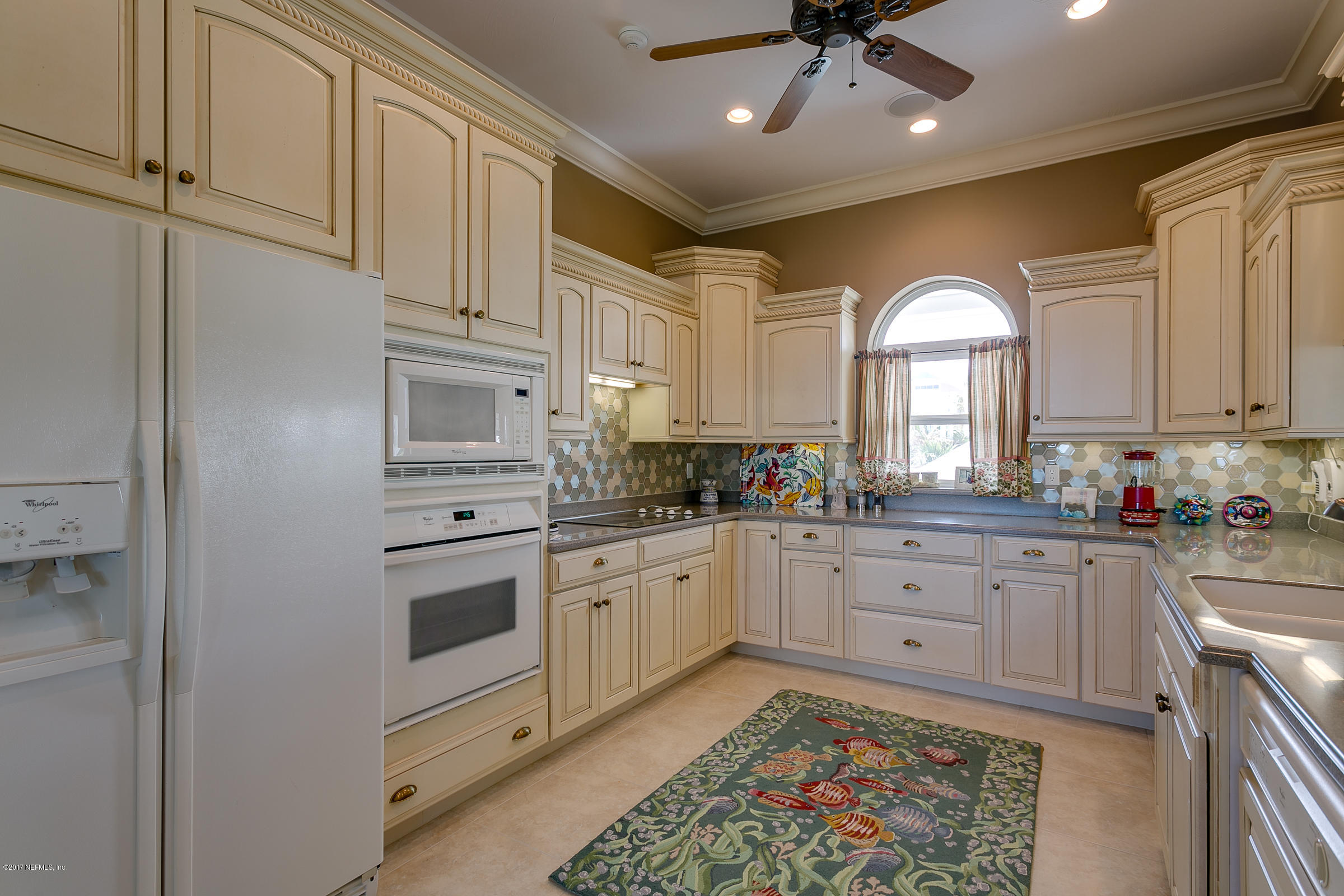 645 Ocean Palm Way St. Augustine, FL 32080 - Photo 25 of 47 a kitchen with granite countertop white cabinets and white appliances