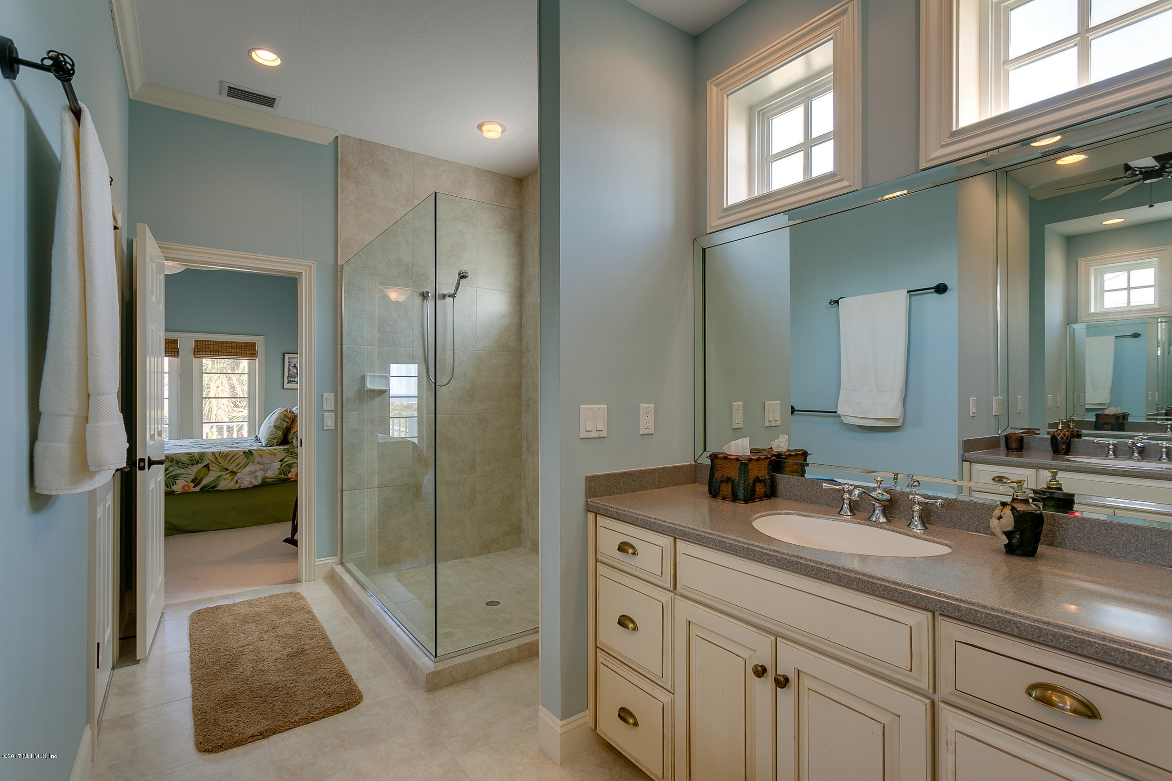 645 Ocean Palm Way St. Augustine, FL 32080 - Photo 33 of 47 a spacious bathroom with a shower a sink and mirror