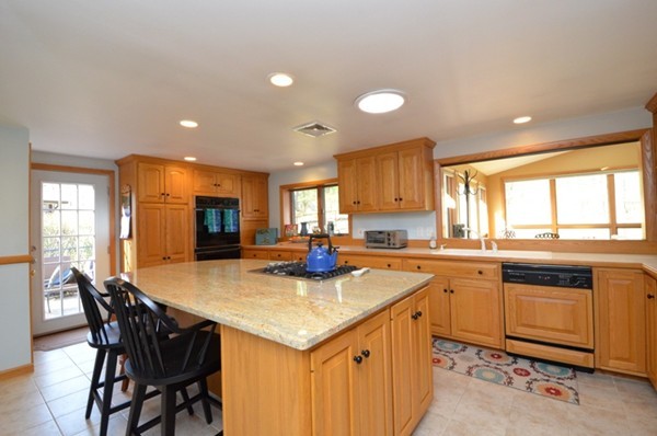 140 Prescott Road Northbridge, MA 01588 - Photo 3 of 22 a kitchen with a stove a sink a dining table and chairs