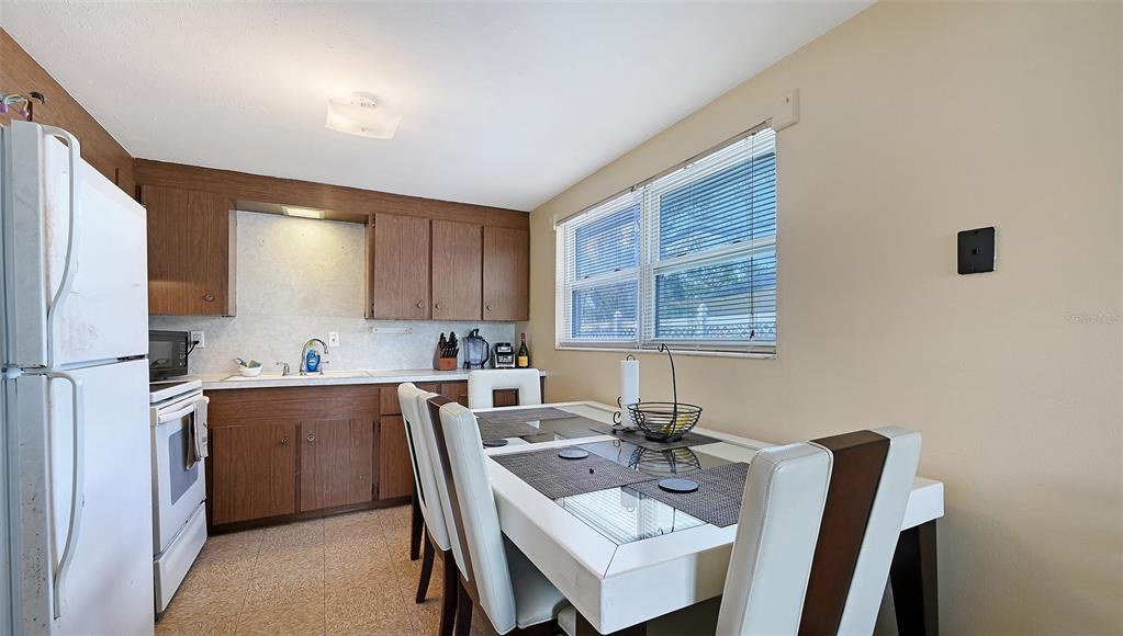 1860 7th Street Sarasota, FL 34236 - Photo 25 of 75 a kitchen with a dining table chairs and refrigerator