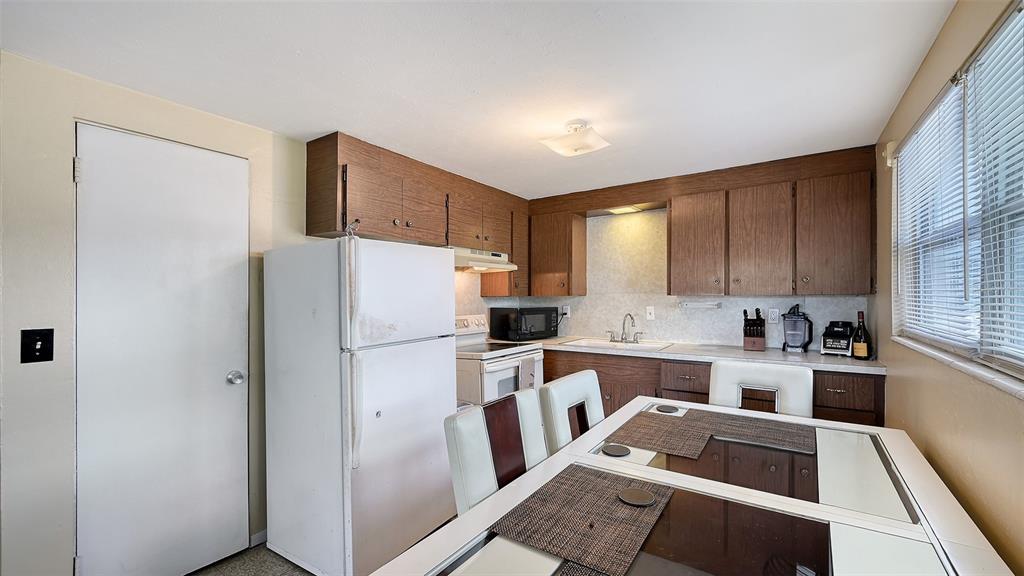 1860 7th Street Sarasota, FL 34236 - Photo 26 of 75 a kitchen with a refrigerator a stove a sink dishwasher and wooden cabinets with wooden floor