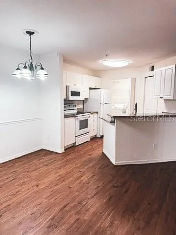 a view of a kitchen with stainless steel appliances wooden floor and a sink
