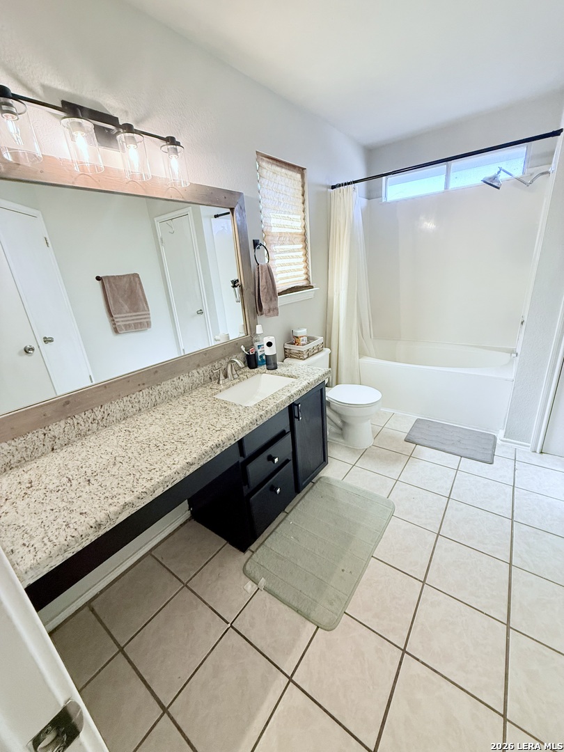 13916 Randalstone Drive Pflugerville, TX 78660 - Photo 16 of 32 a spacious bathroom with a granite countertop sink a toilet a mirror and shower