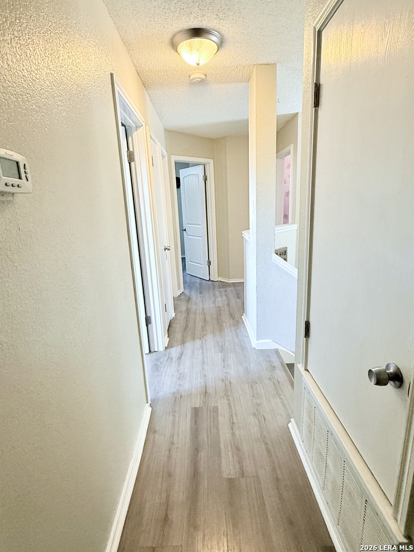 13916 Randalstone Drive Pflugerville, TX 78660 - Photo 23 of 32 a view of a hallway with wooden floor
