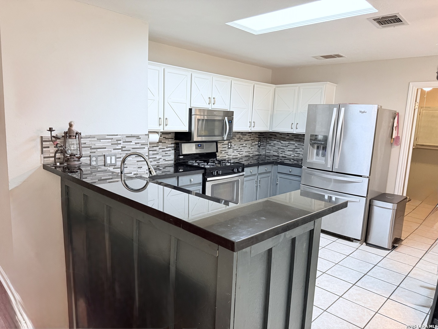 13916 Randalstone Drive Pflugerville, TX 78660 - Photo 9 of 32 a kitchen with stainless steel appliances a sink a stove a refrigerator cabinets and a counter top space